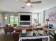Cozy living room with a modern fireplace, large TV, comfortable seating, and bright natural light at 2120 Lilipetal Ct, Sanford, FL 32771