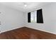 Empty bedroom with hardwood floors, neutral paint, and large window with curtains at 2340 Hinsdale Dr, Kissimmee, FL 34741