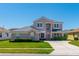 Charming two-story home featuring a well-manicured lawn, lush landscaping, and neutral color palette at 2340 Hinsdale Dr, Kissimmee, FL 34741