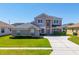 Charming two-story home featuring a well-manicured lawn, lush landscaping, and neutral color palette at 2340 Hinsdale Dr, Kissimmee, FL 34741