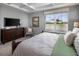 Relaxing bedroom featuring a tray ceiling, large window, and neutral color scheme, offering a tranquil retreat at 2363 Distant Sun Trl, Kissimmee, FL 34747