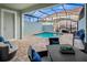 Private screened-in pool area with outdoor seating and dining space at 2367 Distant Sun Trl, Kissimmee, FL 34747