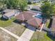 Aerial view of a single-story brick house highlighting the roof, driveway, and surrounding neighborhood at 2470 Pine Tree Circle Dr, Orange City, FL 32763