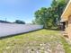 Large backyard boasting a well-maintained lawn, white privacy fence and mature shade trees at 2470 Pine Tree Circle Dr, Orange City, FL 32763