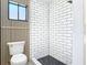 Modern bathroom with subway tile shower, decorative wall paneling, black hardware and a window at 2470 Pine Tree Circle Dr, Orange City, FL 32763