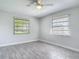 Inviting bedroom with two large windows, wood-look floors, a ceiling fan and serene natural light at 2470 Pine Tree Circle Dr, Orange City, FL 32763