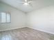Bright, vacant bedroom with wood-look tile flooring, neutral paint, and a window for natural light at 2470 Pine Tree Circle Dr, Orange City, FL 32763