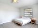 Bedroom with natural light, wood-look tile flooring, and a large window next to a double bed at 2470 Pine Tree Circle Dr, Orange City, FL 32763