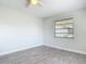 Clean bedroom with wood-look tile flooring, soft, neutral paint, and window, providing a serene and welcoming space at 2470 Pine Tree Circle Dr, Orange City, FL 32763
