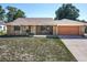 Charming single-story brick home featuring an attached garage and well-maintained front yard at 2470 Pine Tree Circle Dr, Orange City, FL 32763