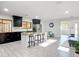 Bright, open kitchen with an island, stainless steel appliances, and dark cabinetry, seamlessly connected to the living area at 2470 Pine Tree Circle Dr, Orange City, FL 32763