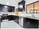 Modern kitchen featuring dark cabinets, stainless steel appliances, granite countertops, and white subway tile at 2470 Pine Tree Circle Dr, Orange City, FL 32763