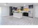 Bright, open kitchen with an island, stainless steel appliances, and dark cabinetry, seamlessly connected to the living area at 2470 Pine Tree Circle Dr, Orange City, FL 32763