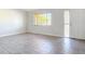 Bright living room area highlighting wood-look tile flooring, a large window, and ample natural light at 2470 Pine Tree Circle Dr, Orange City, FL 32763