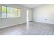 Bright living room area with wood-look tile flooring, a window, and a door leading outside at 2470 Pine Tree Circle Dr, Orange City, FL 32763
