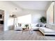 Bright living room with a large white couch, modern decor, and wood-look tile flooring at 2470 Pine Tree Circle Dr, Orange City, FL 32763