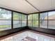 Enclosed sunroom with tile floor and black framed glass windows providing natural sunlight and outdoor scenery at 2470 Pine Tree Circle Dr, Orange City, FL 32763