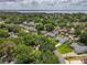 Aerial view showcases a residential neighborhood near a lake, with lush greenery and well-maintained homes at 2647 Lake Landing Blvd, Eustis, FL 32726