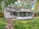 Charming home with a screened-in porch and lush, verdant backyard with trees and native landscaping at 2647 Lake Landing Blvd, Eustis, FL 32726