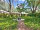 View of backyard and lush garden area with mature trees and wood fence at 2647 Lake Landing Blvd, Eustis, FL 32726