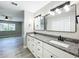 Nicely decorated bathroom with dual vanity, granite counter tops, gray wood-look floors, and stainless steel hardware at 2647 Lake Landing Blvd, Eustis, FL 32726