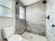 Beautiful bathroom with marble tiled walls, rain shower head, rock floor, and two windows for natural lighting at 2647 Lake Landing Blvd, Eustis, FL 32726
