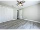 This bedroom features gray wood-look flooring, a ceiling fan, and a closet at 2647 Lake Landing Blvd, Eustis, FL 32726