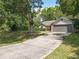 Traditional-style home featuring an expansive driveway and a well-maintained lawn at 2647 Lake Landing Blvd, Eustis, FL 32726