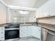 This kitchen features stainless appliances, granite counters, white cabinets, and gray floors with views to the backyard at 2647 Lake Landing Blvd, Eustis, FL 32726