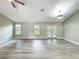 Bright living room featuring wood-look flooring, a ceiling fan, and natural light from the windows and French doors at 2647 Lake Landing Blvd, Eustis, FL 32726
