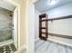 Walk-in closet with custom wood shelving system and access to bathroom with shower at 2647 Lake Landing Blvd, Eustis, FL 32726