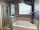 Luxurious bathroom with a large soaking tub, separate shower, and natural light at 2865 Running Brook Cir, Kissimmee, FL 34744