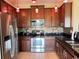 A well-appointed kitchen featuring stainless steel appliances, granite countertops, and wood cabinetry at 2865 Running Brook Cir, Kissimmee, FL 34744