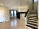 Spacious living room with neutral walls, decorative chandelier, and access to the staircase and dining area at 2865 Running Brook Cir, Kissimmee, FL 34744