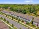 An aerial view of townhomes lining a street surrounded by green trees in a peaceful, residential neighborhood at 3039 Springwell Loop, Orlando, FL 32808