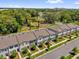 An aerial view of a townhome community and a park with lush landscaping, surrounded by green trees and a playground at 3039 Springwell Loop, Orlando, FL 32808