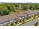 A street view of townhomes with muted color schemes and colorful front doors surrounded by mature landscaping at 3039 Springwell Loop, Orlando, FL 32808