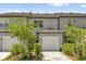 Charming townhouse showcases a well-maintained front yard with lush landscaping, leading to a single-car garage at 3039 Springwell Loop, Orlando, FL 32808