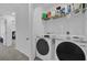 Modern laundry room with front loading washer and dryer and a shelf for storage, showcasing convenience at 3039 Springwell Loop, Orlando, FL 32808