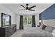 Bright main bedroom featuring a ceiling fan, modern dresser, and window at 3039 Springwell Loop, Orlando, FL 32808