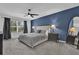 Main bedroom with blue accent wall, ceiling fan, large window, and comfortable bed at 3039 Springwell Loop, Orlando, FL 32808
