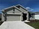 Charming single-story home featuring a two-car garage, well-manicured lawn, and neutral exterior paint at 34071 Sky Blossom Cir, Leesburg, FL 34788