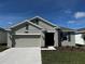 Charming single-story home featuring a two-car garage, well-manicured lawn, and neutral exterior paint at 34071 Sky Blossom Cir, Leesburg, FL 34788