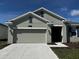 Charming single-story home featuring a two-car garage, well-manicured lawn, and neutral exterior paint at 34071 Sky Blossom Cir, Leesburg, FL 34788