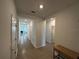 Bright hallway with tile flooring, white walls, and multiple doorways, offering a clean and modern aesthetic at 34071 Sky Blossom Cir, Leesburg, FL 34788