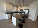 Modern kitchen with white cabinets, stainless steel appliances, an island with seating, and tile flooring at 34071 Sky Blossom Cir, Leesburg, FL 34788