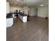 Open concept kitchen with white cabinets, stainless steel appliances, a central island, and seamless flow to the living area at 34071 Sky Blossom Cir, Leesburg, FL 34788