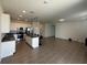 Open concept kitchen with white cabinets, stainless steel appliances, a central island, and seamless flow to the living area at 34071 Sky Blossom Cir, Leesburg, FL 34788