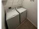Convenient laundry room complete with modern white washer and dryer set and wire shelving at 34071 Sky Blossom Cir, Leesburg, FL 34788