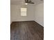 The bedroom has hard wood flooring, a ceiling fan, and a window for natural light at 35 Aberdeen Cir, Leesburg, FL 34788